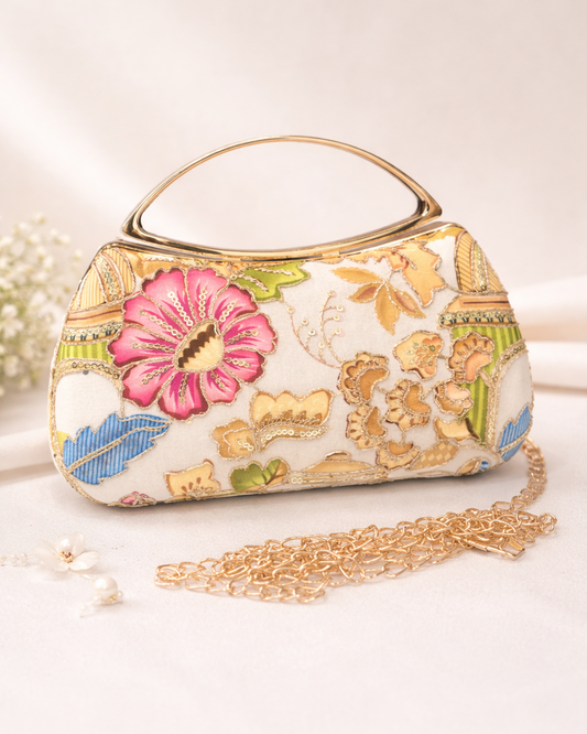 Decorative handbag with floral patterns and a chain strap on a light background