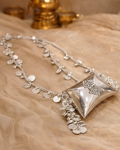 Gold and silver necklaces on a textured surface