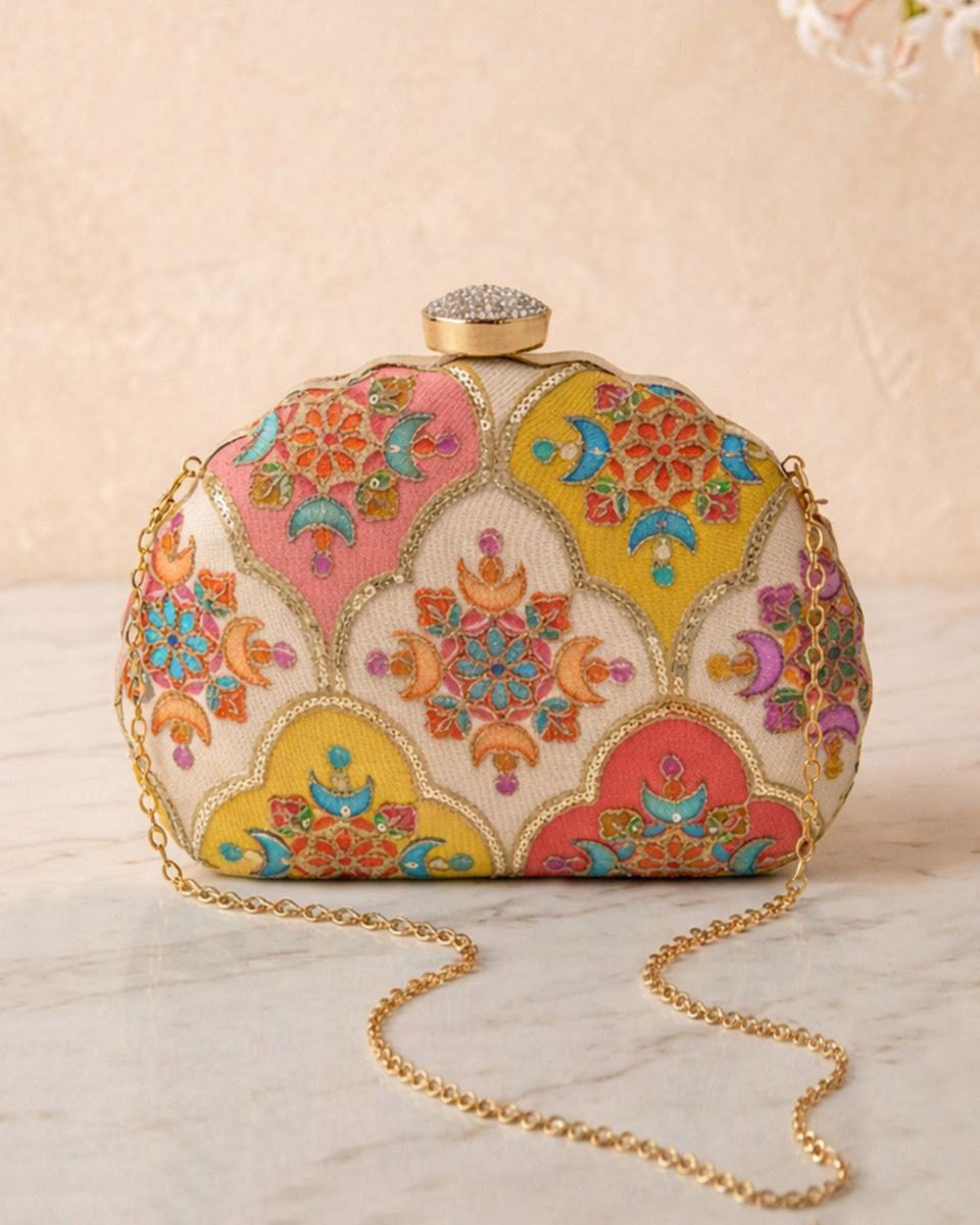 Colorful embroidered clutch bag with a gold chain on a beige background