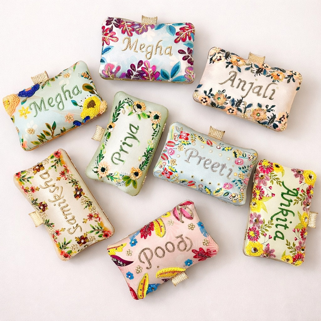 Colorful clutches with floral designs and names embroidered on a white background