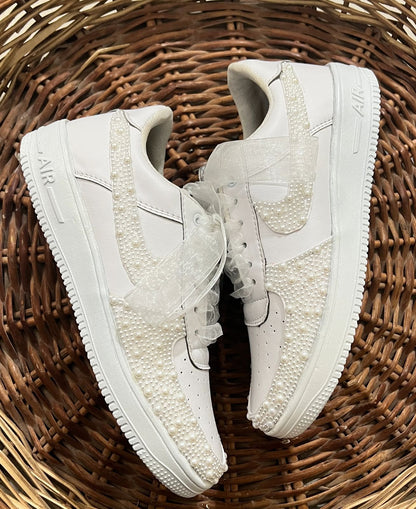 White sneakers with lace details on a woven surface